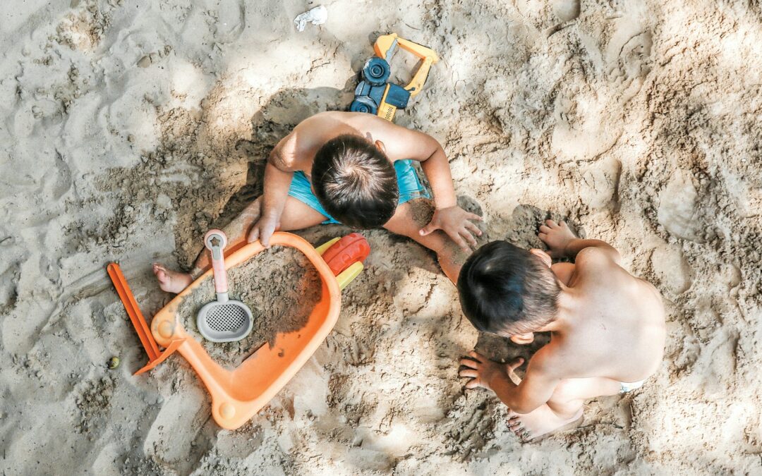 Dos niños jugando en la arena de la playa del Arenal de Jávea con juguetes de playa
